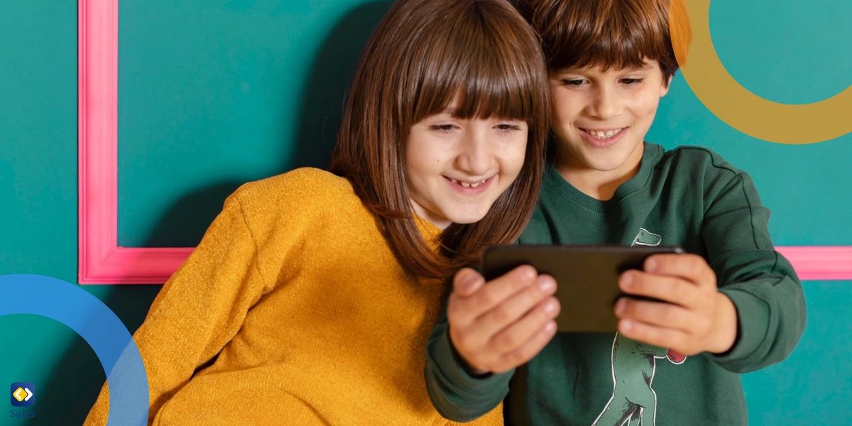 A boy and a girl, likely siblings, sitting together at home, joyfully sharing a smartphone screen against a teal background.