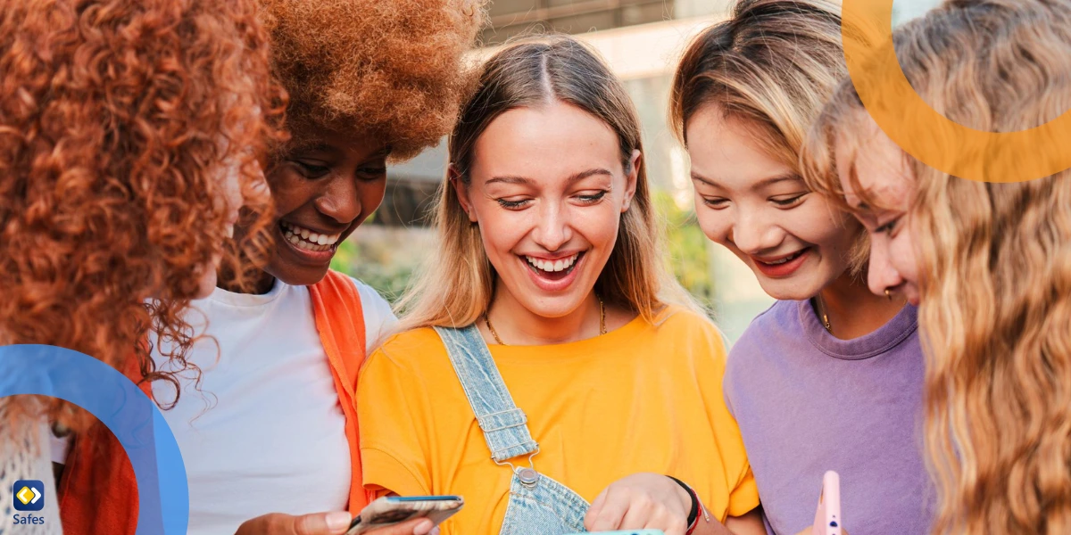 group of teens using their phones and laughing